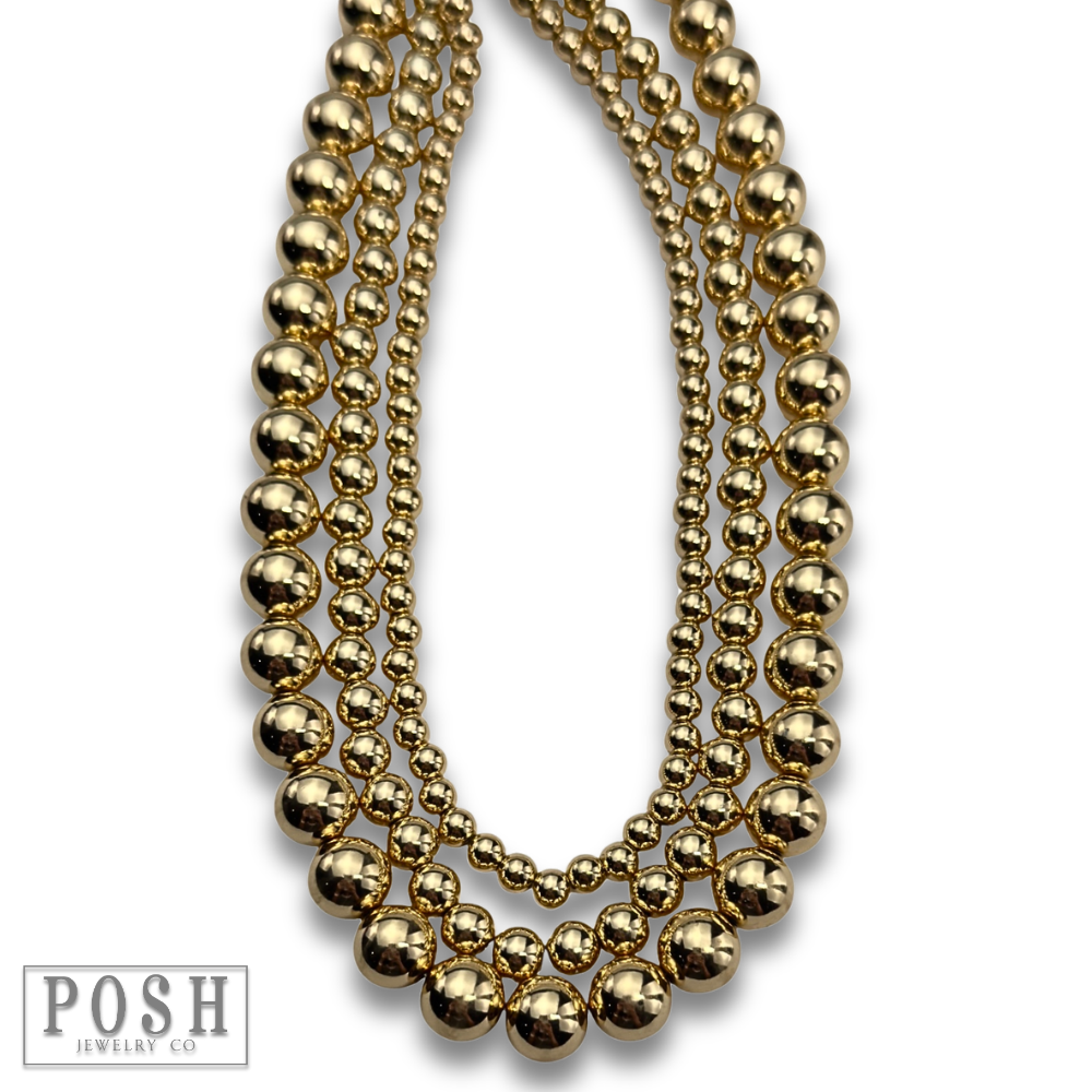 Three strand gold beaded necklace
